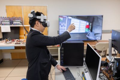 Nguyen Khoa Nguyen wears a virtual reality headset while demonstrating the digital twin and virtual reality system at a recent Power and Energy Conference at Virginia Tech.